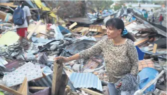  ?? Picture: AFP ?? DEVASTATED. Nonlis Kando stands among the debris of her home in Petobo, Indonesia, following the September 28 earthquake and tsunami.