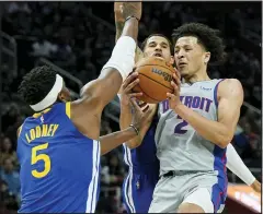  ?? CARLOS OSORIO — THE ASSOCIATED PRESS ?? Detroit Pistons guard Cade Cunningham (2) runs into the defense of Golden State Warriors center Kevon Looney (5) during the first half of Friday’s game in Detroit.