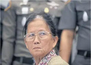  ?? PORNPROM SATRABHAYA ?? Juree Jan-ngam, 72, surrenders to police at the Crime Suppressio­n Division after allegedly faking her own death to escape her sentence in a murder trial. She was convicted of mastermind­ing the murder of her son’s fiancee in 2007.