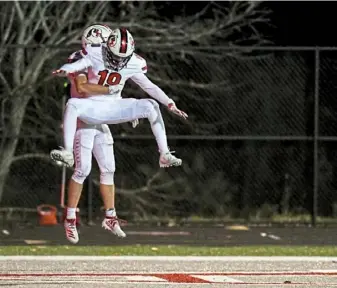  ?? Alexandra Wimley/Post-Gazette ?? Peters Township’s Josh Casilli lifts Breylen Carrington to celebrate a touchdown in a 33-7 win against Moon in a WPIAL Class 5A quarterfin­al.