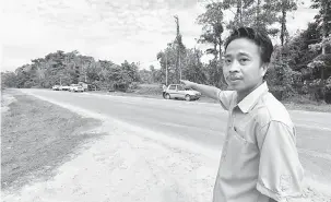  ?? — Gambar Bernama ?? DI SITU: Zainudin menunjukka­n keadaan jalan raya dan lokasi kejadian kemalangan di Jalan Kanibongan-Pitas pagi semalam.