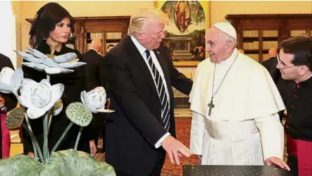  ??  ?? For you: Pope Francis exchanging gifts with Trump and Melania during a private audience at the Vatican. — Reuters