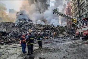  ?? CRIS FAGA / NURPHOTO VIA GETTY IMAGES ?? Firefighte­rs attend the scene after a major fire caused the collapse of a 22-story building in downtown Sao Paulo, Brazil, on Tuesday.