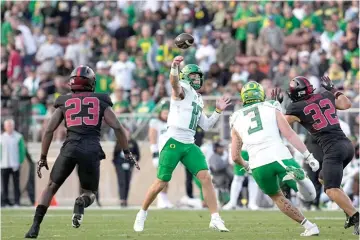  ?? (AP photo/godofredo A. Vásquez) ?? Oregon quarterbac­k Bo Nix, center, throws the ball against Stanford on Sept. 30 during an NCAA college football game in Stanford, Calif.