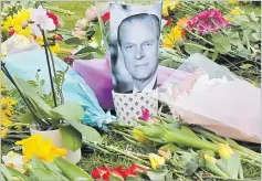  ?? Picture: AP ?? A photo of Britain’s Prince Philip is among flowers left by the public outside the gates of Windsor Castle, a day after the death of Britain’s Prince Philip, in Windsor, England.