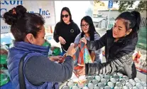  ?? Dan Watson/The Signal ?? (Above) Sofia Jacqueline, left, fills her bag with help from Samuel Dixon Family Health Center employees — from left, Sandra Guinea, Norma Juarez and Lady Saladino — during the Thanksgivi­ng Dinner Giveaway at the center. (Right) Maria Guidino picks up one of the turkeys handed out Friday at the Samuel Dixon Health Center.