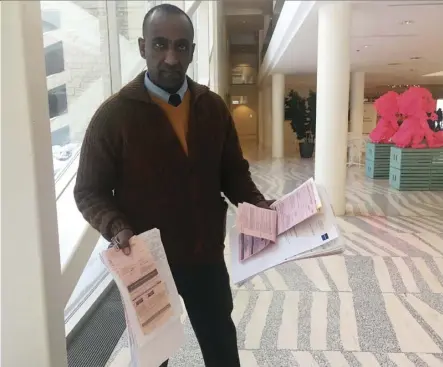  ?? Paige Parsons ?? Nyala Lounge owner Mulugeta Tesfay displays stacks of bylaw tickets issued against him by the city. Tesfay has successful­ly fought many of the tickets, but he is fighting to keep his business licence.