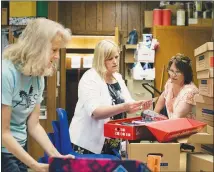  ?? ALYSSA SCHUKAR / THE NEW YORK TIMES ?? School staff members organize books and supplies for an end-of-year book sale at Arena Community Elementary School. The school in Arena, Wis., population 834, closed its doors for good earlier this month. The action will force future students in the...