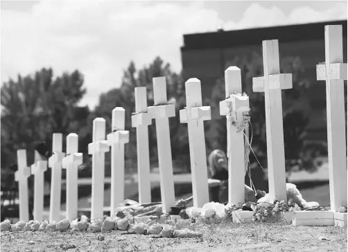  ?? SHANNON STAPLETON, REUTERS ?? Crosses are seen Sunday at a memorial for victims behind the theatre where a gunman opened fire on moviegoers in Aurora, Colo.