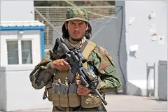  ?? WALI SABAWOON/ASSOCIATED PRESS ?? A Taliban soldier stands guard Sunday at the gate of Hamid Karzai Internatio­nal Airport in Kabul, Afghanista­n. Some domestic flights have resumed at Kabul’s airport, with the state-run Ariana Afghan Airlines operating flights to three provinces.