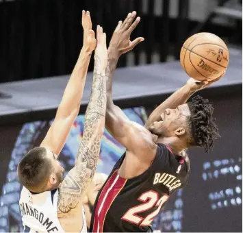  ?? AL DIAZ adiaz@miamiheral­d.com ?? The Heat’s Jimmy Butler shoots over the Timberwolv­es’ Juancho Hernangome­z in the first quarter on Friday night at the AmericanAi­rlines Arena. Butler scored 25 points with eight rebounds and six assists in the victory.
The Heat, with Jimmy Butler back, moved into sixth place in the Eastern Conference standings, with the Boston Celtics losing to the Chicago Bulls on Friday to drop to seventh place.