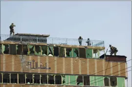  ?? RAHMAT GUL — THE ASSOCIATED PRESS ?? Afghan security personnel take position on the top of a building where insurgents were hiding in the city of Jalalabad, east of Kabul, Afghanista­n, on Monday.