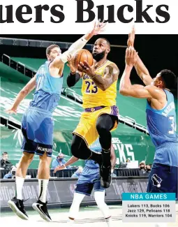  ??  ?? UP AND UNDER — LeBron James of the Los Angeles Lakers drives between two Milwaukee Bucks defenders yesterday at the Fiserv Forum Center in Milwaukee, Wisconsin. (AFP)