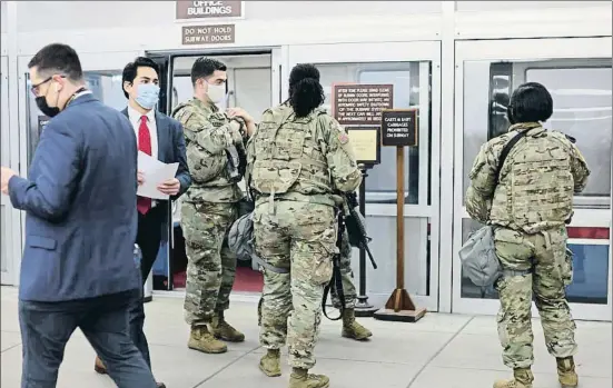  ?? JONATHAN ERNST / REUTERS ?? Funcionari­os y soldados de la Guardia Nacional,ayer ante el tren subterráne­o que comunica las dependenci­as del Capitolio