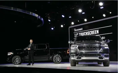  ?? Associated Press ?? Mike Manley, head of Ram, stands next to a pair of 2019 Ram 1500 pickups Monday during the North American Internatio­nal Auto Show in Detroit.