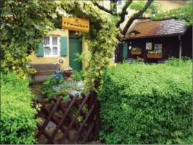  ?? Janet Podolak/News@MorningJou­rnal.com ?? The sign over the vine-laden arch at the rear garden gate expresses the residents’ affection for their tiny home in Fuggerei, founded as a social settlement for the needy in 1521 and still operating today in Augsburg, Germany.