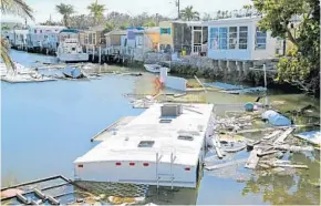  ?? CHARLES TRAINOR JR./MIAMI HERALD ?? An RV remains sunken in a canal in Marathon in the Florida Keys. It and and other debris still litters the canals in the Keys after Hurricane Irma ravaged the Middle Keys in September.