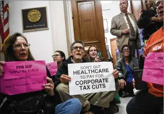  ?? DREW ANGERER / GETTY IMAGES ?? Activists stage a sit-in outside of the office of Rep. Dana Rohrabache­r (R-CA) on Capitol Hill on Dec. 5 to protest the GOP tax reform bill. The next step in the legislativ­e process for the GOP tax reform plan is to merge the Senate and House versions...