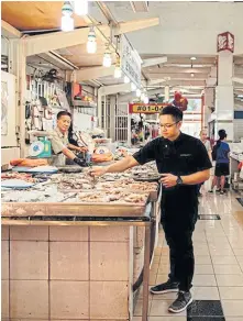  ??  ?? Malcolm Lee shops for fresh seafood and other local produce at Tekka Market.