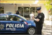  ?? SEBASTIAN LOPEZ BRACH — THE ASSOCIATED PRESS ?? Police gather outside the Unico supermarke­t, a grocery chain owned by soccer player Lionel Messi's in-laws, after it was shot at in Rosario, Argentina, on Thursday.