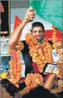  ?? AFP/PTI ?? (Clockwise from above) Wrestler Ravi Dahiya being received by fans after the Indian Olympic contingent landed in New Delhi on Monday evening. The Indian women’s hockey team, Olympic champion Neeraj Chopra showing the gold medal to the crowd, wrestler Bajrang Punia being carried on the shoulders of well wishers and hockey player Rupinder Pal Singh clicking a selfie with Chopra and the crowd on arrival at the IGI Airport.