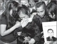  ?? AP/MARCO UGARTE ?? The sister, nieces and nephews of the Rev. Jose Alfredo Suarez de la Cruz watch his casket lower into the floor Wednesday inside Our Lady of Asuncion Church in Paso Blanco, Veracruz state, Mexico.