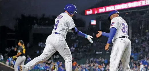  ?? CHARLES REX ARBOGAST/AP ?? Ian Happ is congratula­ted by third-base coach Willie Harris after his homer, which got the Cubs off to a strong start against the Pirates’ Luis Ortiz.