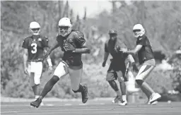  ??  ?? Cardinals quarterbac­k Sam Bradford throws a pass to wide receiver Larry Fitzgerald during practice on Wednesday at the Cardinals Training Facility in Tempe, Ariz. ROB SCHUMACHER/THE REPUBLIC