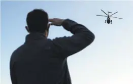  ?? WIN MCNAMEE GETTY IMAGES ?? A young man salutes as Marine One, the presidenti­al helicopter, carries President Donald Trump away from the White House.