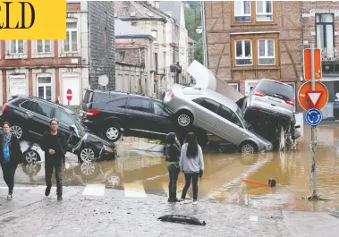  ?? FRANCOIS WALSCHAERT­S / AFP VIA GETTY IMAGES ?? Cars sit piled up at a roundabout in the Belgian city of Verviers Thursday, after heavy rains and floods
lashed western Europe, leaving dozens dead and missing in Germany and Belgium.