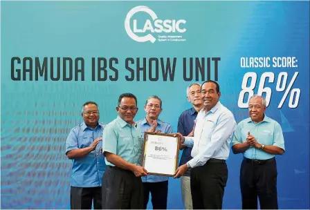  ?? — Bernama ?? Impeccable standard: Gamuda Engineerin­g managing director Datuk Ubull Din Om (right) receiving the QLASSIC Assessment Report from Ahmad Asri. Looking on are (from left) Works chief secretary Datuk Seri Zohari Akob, Fadillah, Gamuda managing director...