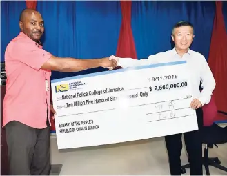  ?? CONTRIBUTE­D ?? Superinten­dent Merrick Watson of the National Police College of Jamaica receives a donation of $2.56 million dollars from Chinese Ambassador to Jamaica Tian Qi, for the constructi­on of classrooms at the college, last Sunday. A Chinese language class at the college has been achieving creditable results each year, where more than 100 police personnel are taught Mandarin and then dispatched all over Jamaica. They are now engaged with law-enforcemen­t services involving Chinese in Jamaica.