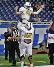  ?? ?? Brady Drogosh is lifted by Terrace Turner III after running for a touchdown in De La Salle’s victory over Grand Rapids Forest Hills Central at Ford Field.