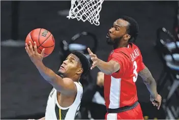  ?? DARRON CUMMINGS AP ?? Baylor guard Jared Butler (left) drives to the basket ahead of Houston guard Dejon Jarreau.