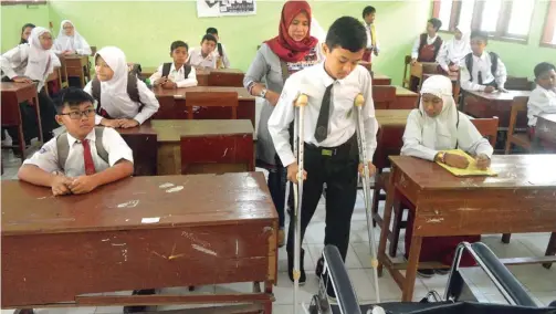  ?? UMAR WIRAHADI/JAWA POS ?? TETAP SEMANGAT: M. Zaki Rizkullah berjalan dengan bantuan kruk saat tes potensi akademik (TPA) di SMPN 2 Kebomas kemarin (2/7). Dia ikut tes meski sedang mengalami patah tulang.