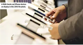  ??  ?? A MAN checks out iPhone devices on display in this 2016 file photo.