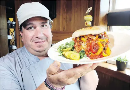  ?? NICK BRANCACCIO ?? Mettawas Station Italian Mediterran­ean Grill owner Anthony Del Brocco proudly displays his Train Wreck veal sandwich on Tuesday. He is among the finalists in the Veal Farmers of Ontario’s best veal sandwich competitio­n.