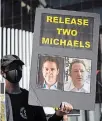  ?? THE CANADIAN PRESS FILE PHOTO ?? A demonstrat­or holds a sign with photograph­s of Michael Kovrig and Michael Spavor, who have been detained in China since December 2018.