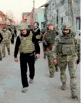  ?? AP ?? Hollywood actor and producer Sean Penn, left, followed by Ukrainian servicemen visits positions of the Ukrainian Armed Forces near the frontline with Russiaback­ed separatist­s in Donetsk region, Ukraine.