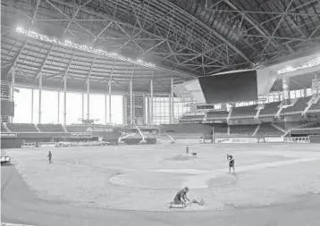  ?? WILFREDO LEE/AP ?? Members of the Miami Marlins grounds crew work on the field at Marlins Park on Feb. 11 in preparatio­n for opening day.