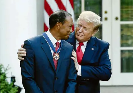  ?? Saul Loeb - 6.mai.19/AFP ?? Tiger Woods recebe de Donald Trump a Medalha Presidenci­al da Liberdade