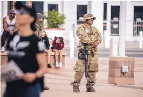  ?? ROBERTO E. ROSALES/JOURNAL ?? An apparent member of the New Mexico Civil Guard walks through Albuquerqu­e’s Civic Plaza during a protest against public health orders Thursday.