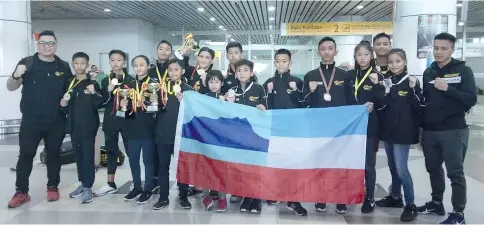  ??  ?? Sabah's young exponents with coach Rayner Kinsiong (left) receive a warm welcome upon returning from the National Inter-School Muaythai Junior Championsh­ips that was held in Selangor.