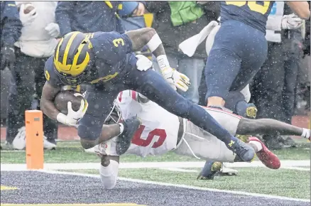  ?? CARLOS OSORIO – THE ASSOCIATED PRESS ?? Michigan wide receiver A.J. Henning scores on a 14-yard slot-around play to cap the game’s opening drive Saturday against visiting Ohio State.