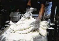  ?? SUNDAY ALAMBA/AP ?? A worker prepares flour for bread inside a bakery in Lagos, Nigeria. One official in Nigeria said, “A lot of people have stopped eating bread; they have gone for alternativ­es because of the cost.’’