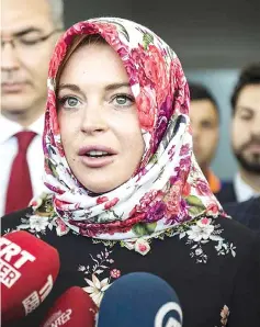  ??  ?? Lohan wears a headscarf given to her by a Syrian woman after visiting Syrian refugees in Turkey last Oct 8. — File photo