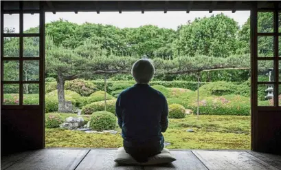  ?? — AFP ?? Green and serene: Gardener Chisao Shigemori sitting in front of a Japanese garden covered with different types of moss in Kyoto. (Right) Shibo examining moss during a moss viewing tour at Kita-Yatsugatak­e forest near Sakuho town, Nagano prefecture.