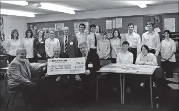  ?? 01_B02twe02 ?? Teacher Dave McKay and his pupils receive a cheque for £2,000 from Iain Russell of Arran Aromatics who sponsored an understand­ing industry course for 6th year pupils at Arran High School.