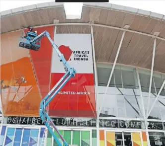  ?? ?? WORKERS at Durban’s Internatio­nal Convention Centre (ICC) put the final touches to a banner for Africa’s Travel Indaba, which starts today. | DOCTOR NGCOBO Independen­t Newspapers