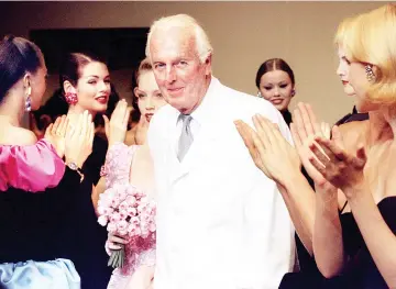  ??  ?? French fashion designer Hubert de Givenchy is applauded by the models after he presented his last High Fashion collection Autumn/Winter 1995 in Paris July 11. • (Below, right) In this file photo taken on October 21, 1991 Givenchy (Left) and American...